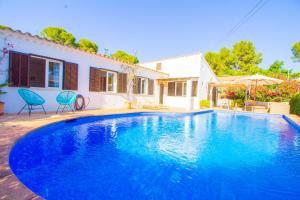 a large blue swimming pool in front of a house at Beautiful villa near the beach in Port de Pollensa