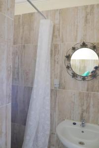 un baño con lavabo y espejo en The Village Retreat, en Phalaborwa