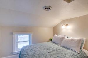 a bedroom with a bed with white pillows and a window at Family-Friendly House Walk to Lake Michigan! in Sheboygan
