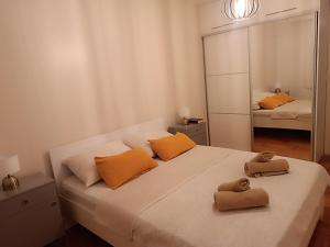 a bedroom with a bed with orange pillows and a mirror at Top Center Apartment in Bijeljina