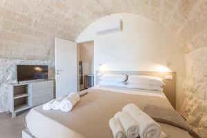 a bedroom with a large bed with towels on it at Pajara Marinaia - Antica Liama salentina in Marittima