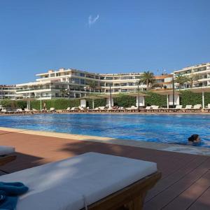a person swimming in a swimming pool with a building at Stunning Sea Front Chalet In Tripoli in Trâblous