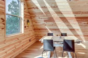 a dining room in a log cabin with a table and chairs at A-Frame Hardy Cabin with Spring River Views! in Hardy
