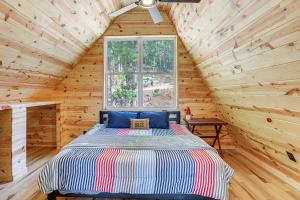 a bedroom with a bed in a wooden cabin at A-Frame Hardy Cabin with Spring River Views! in Hardy