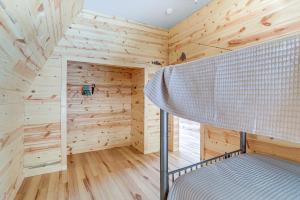 a room with wooden walls and a bunk bed at A-Frame Hardy Cabin with Spring River Views! in Hardy
