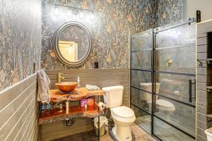 a bathroom with a toilet and a mirror at A-Frame Hardy Cabin with Spring River Views! in Hardy