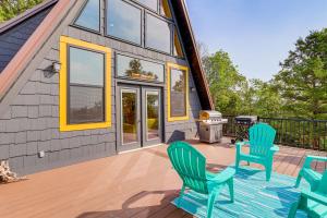 a house with a deck with chairs and a grill at A-Frame Hardy Cabin with Spring River Views! in Hardy