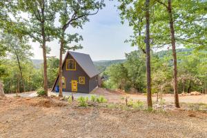 a small house in the woods with trees at A-Frame Hardy Cabin with Spring River Views! in Hardy