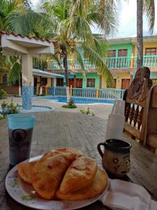 a table with a plate of bread and a cup of coffee at Buzios Posada in Chichiriviche