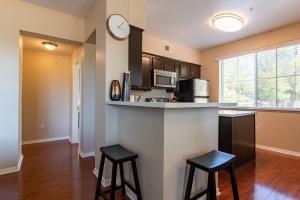 a kitchen with two bar stools and a counter top at Modern Suitevipwifipool2 King Bedsac in Santa Clarita