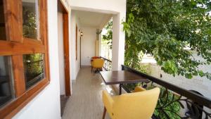 balcón con mesa de madera y sillas amarillas en Pin Traveler House, en Sanlıurfa 10 fotos más