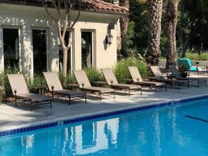 un gruppo di sedie sedute accanto a una piscina di Luxury Suite, Fast Wifi, King Bed, Pool And Spa a Santa Clarita
