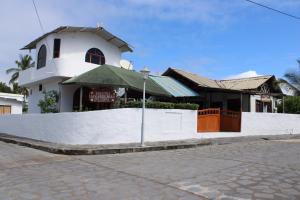 a white building with a sign in front of it at Las Gardenias Hostel - Starlink Internet in Puerto Villamil +35 photos