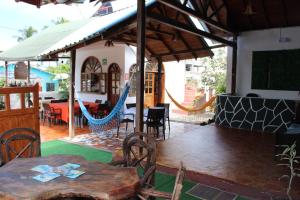 a patio with a table and chairs and a hammock at Las Gardenias Hostel - Starlink Internet in Puerto Villamil