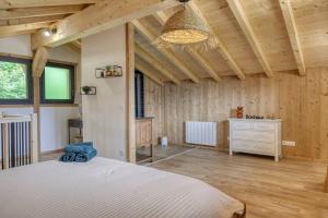sypialnia z dużym łóżkiem i drewnianym sufitem w obiekcie Chalet Marie situé 25km Chamonix w mieście Saint-Gervais-les-Bains