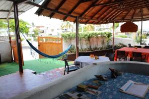 a patio with a hammock and a table and chairs at Las Gardenias Hostel - Starlink Internet in Puerto Villamil