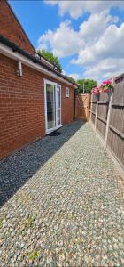 a brick house with a fence and a driveway at Deluxe Town Centre 2 Bedroom Apartment in Stevenage