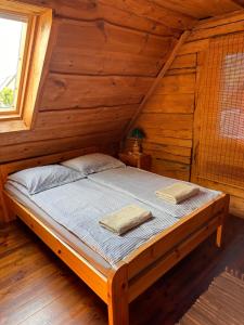 Priežmuiža في بافيلوستا: سرير في كابينة خشب عليها منشفتين