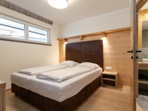 une chambre avec un grand lit avec un mur en bois dans l'établissement Apart33 Top 2-4, à Haus im Ennstal