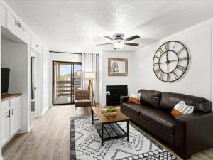 a living room with a couch and a clock on the wall at Turkey Nest By Beyond Expectations Renovated 2br in Gatlinburg