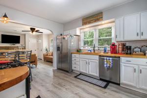 a kitchen with white cabinets and a stainless steel refrigerator at Square Toe's Last Resort in New Buffalo