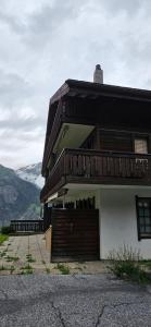 a house with a balcony on the side of it at Ferienwohnung im Haus Castor in Grächen