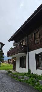 a house with a balcony on the side of it at Ferienwohnung im Haus Castor in Grächen