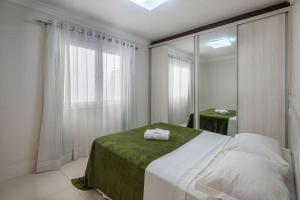 ein Schlafzimmer mit einem großen Bett und einem Spiegel in der Unterkunft GRJA012- Apê na Atlântica com terraço privilegiado in Balneário Camboriú