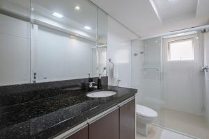 ein Badezimmer mit Waschbecken, Toilette und Dusche in der Unterkunft GRJA012- Apê na Atlântica com terraço privilegiado in Balneário Camboriú + 51 Fotos
