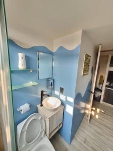 Un baño azul con inodoro y lavabo. en Grand Depa Bellomar, en Acapulco