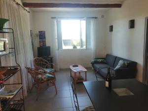 een woonkamer met een bank en een tafel bij la bastide aux buis avec piscine in Blauvac