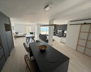 Una cocina y una sala de estar con una mesa y sillas negras. en Sunny Getaway, en La Herradura