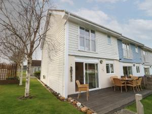 a house with a wooden deck and a table at Whitfield P7 in Yarmouth