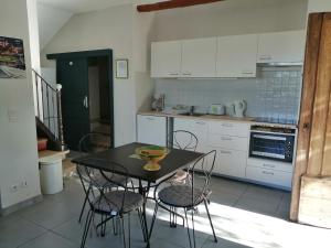 een keuken met een tafel en stoelen in een keuken bij la bastide aux buis avec piscine in Blauvac