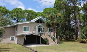 a house with a porch and stairs in a yard at Dog Friendly-Short Walk to Beach-Canal Front-Screened Porch-Peaceful in Sun N Sand Beaches