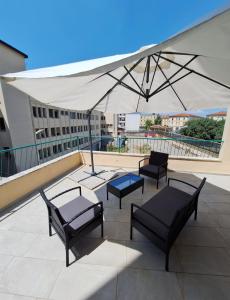 a patio with chairs and a white umbrella at Casa Vanessa in Arezzo