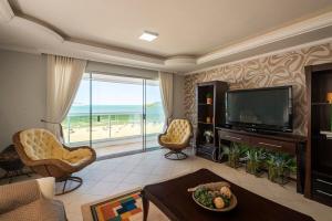 ein Wohnzimmer mit einem TV und Meerblick in der Unterkunft GRJA051- Incrível vista mar | Localização perfeita in Balneário Camboriú