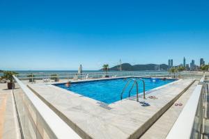 a swimming pool with the ocean in the background at IPTZ160- Frente mar c/ vista incrível do 16º andar in Balneário Camboriú