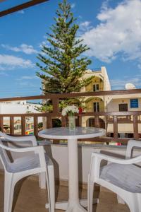 a table and chairs on a balcony with a christmas tree at Hotel Velissarios in Hersonissos