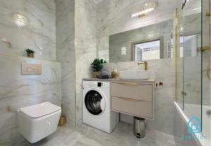 グダニスクにあるLaura Apartment with Sauna & Gym, 5 Min to Baltic Sea & Polsat Plus Arenaの洗濯機と洗面台を備えたバスルーム +32枚の写真