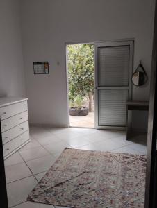 una cucina bianca con una porta aperta sul cortile di Hostel e Camping Recanto das Mandalas a Chapada dos Guimarães
