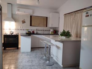 a kitchen with white cabinets and a black refrigerator at Casa Solis in Balneario Solís +17 photos