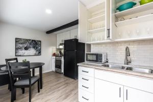 een keuken met een tafel en een zwarte koelkast bij Calmont Guest House in Fort Worth