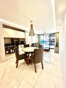 a living room with a table and chairs and a piano at Flat Atlântico 405 in Fortaleza