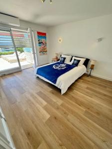 a bedroom with a bed and a wooden floor at Appartement exception les pieds dans l'eau in Èze