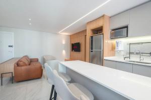 eine Küche und ein Wohnzimmer mit einer Theke und Stühlen in der Unterkunft LFYT135-Alto padrão localização ideal Av Atlântica in Balneário Camboriú