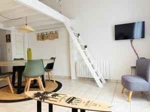 サン・ミシェル・シェフ・シェフにあるChez Karine et Rodolphe La Cosy, piscines, plageのテーブルと椅子とテレビのあるリビングルーム