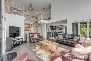 a living room with couches and a table at Arte Natura - familial avec Spa in Petite-Rivière-Saint-François