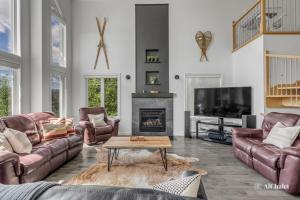 a living room with leather furniture and a fireplace at Arte Natura - familial avec Spa in Petite-Rivière-Saint-François
