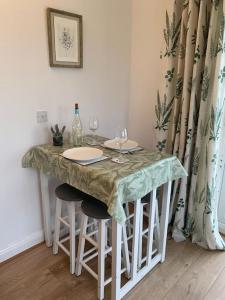 a table with glasses and wine bottles on it at Modern, Stylish lodge with Paddock Views in Sandwich